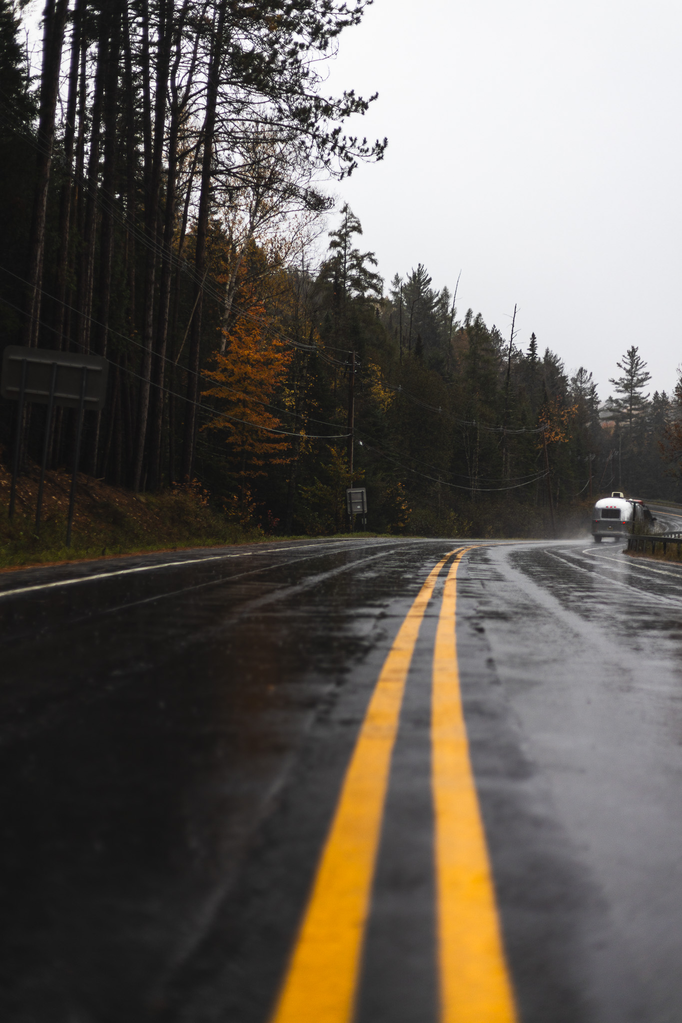 Airstream on a windy wet road in fall foliage