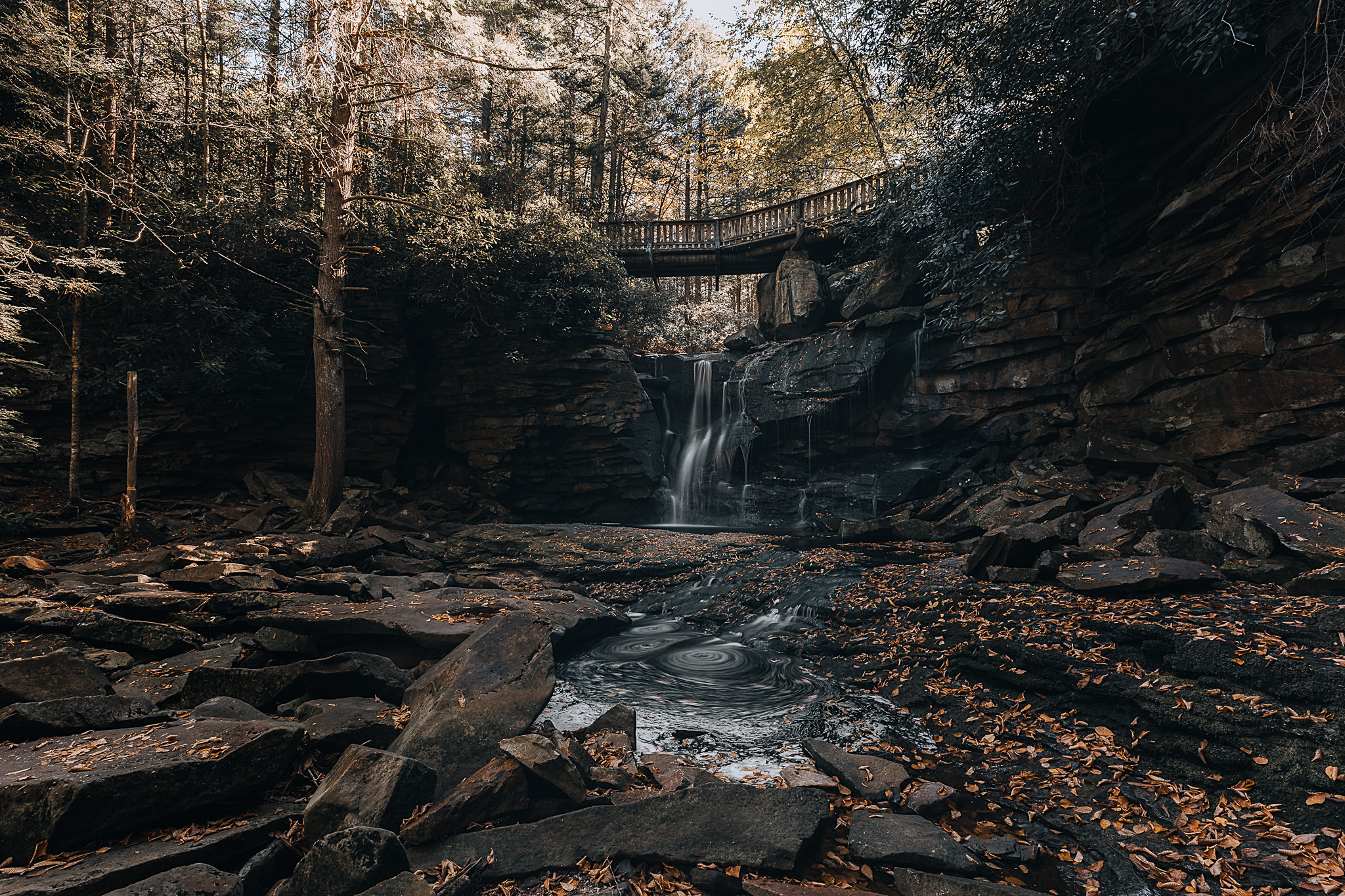 A waterfall with a bridge on top of it