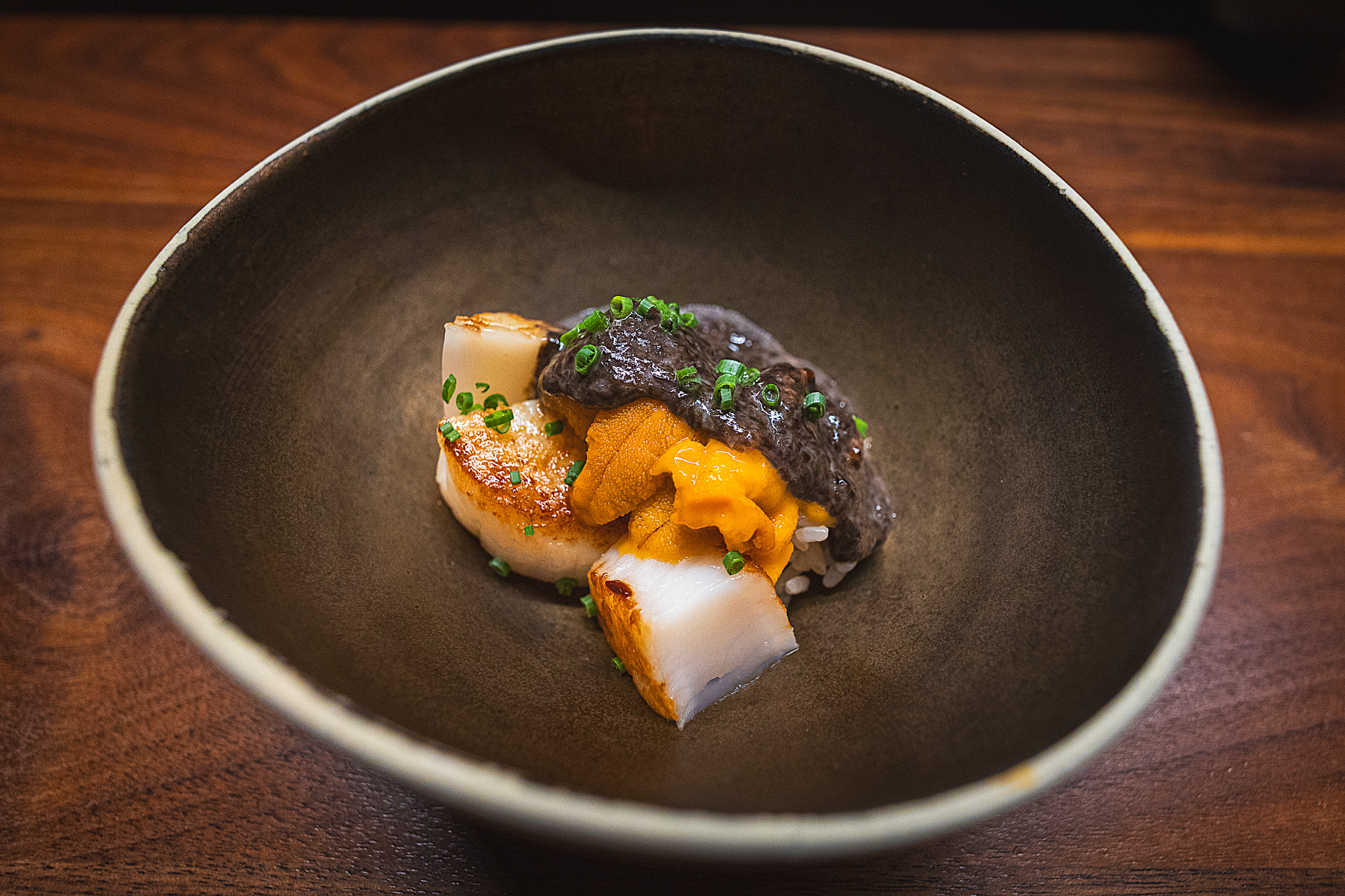 Seared scallops with uni and sauce and a brown bowl