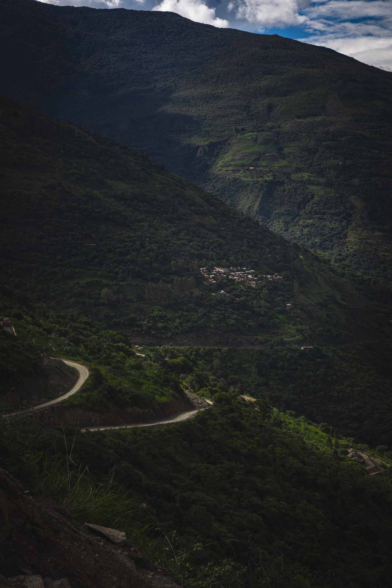 A small town, nestled in the hills with a winding road in the foreground