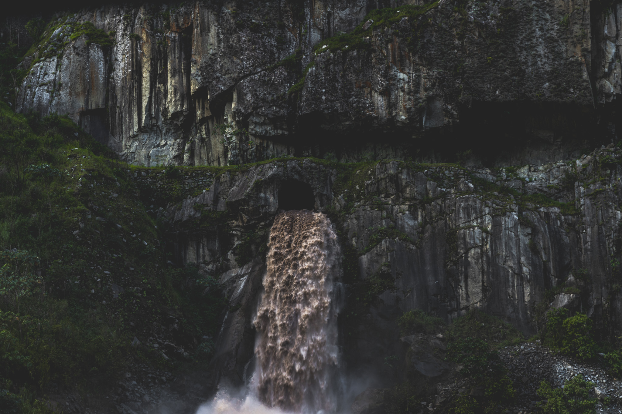 Mighty flowing water out of a dam in the cliff face